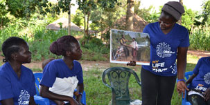 A DREAMS team member shares information with other women.