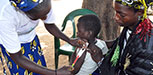 Two children receive supplementary food from a packet