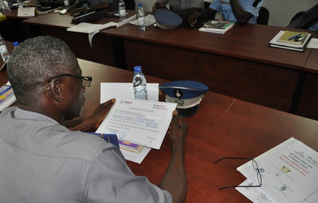 A police officer in Bouake receives his certificate after completing his training on interacting with the court system