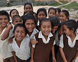 A group of children laugh and smile in a schoolyard in Guyana. © 2014 Lorine Ghabranious/MSH, Courtesy of Photoshare