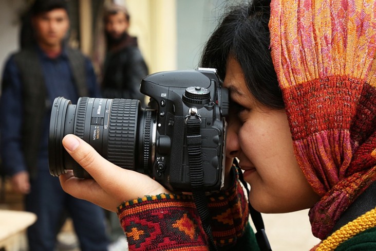 A young photojournalist is looking for the perfect shot, on assignment to capture content for a local company in Kabul.