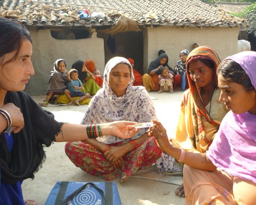 A community health volunteer in Banke district counsels a pregnant woman on the use of Kawach, or chlorhexidine, during a home v