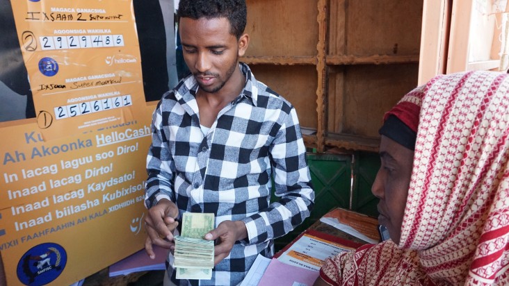 A customer receives money at the Wakiilka HelloCash agent in Jigjiga. Established through a USAID grant, HelloCash enables customers to use their phone to pay for goods in shops or pay bills.