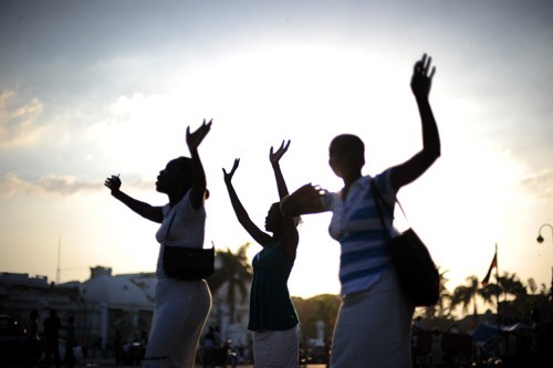 Three Haitian women pray in downtown Port-au-Prince on Feb. 12, 2010.