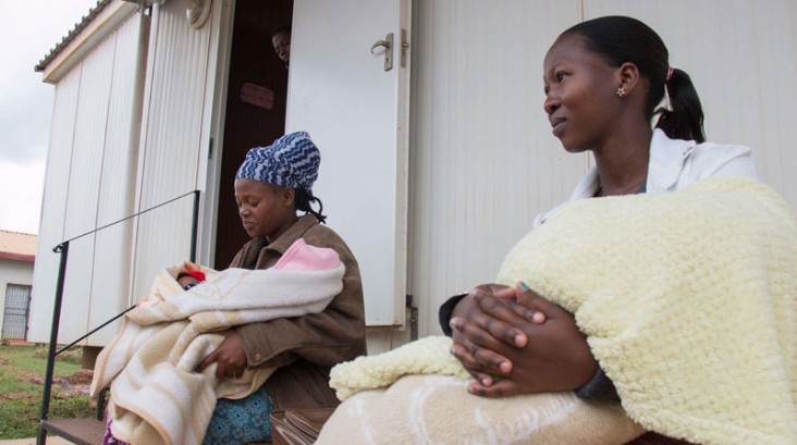 Photo of two women holding their children