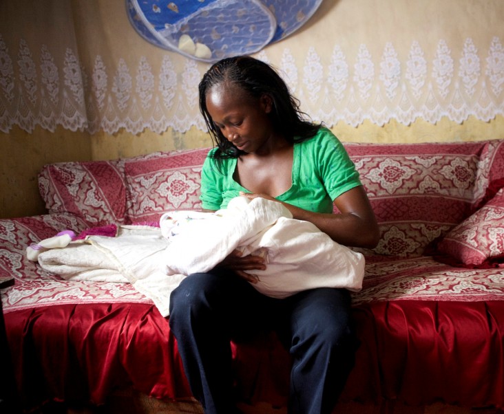 Lillian Kambura holds her newborn son, Paul, in her home in Mwiki, Kenya, as she waits for her three-day postpartum home visit.