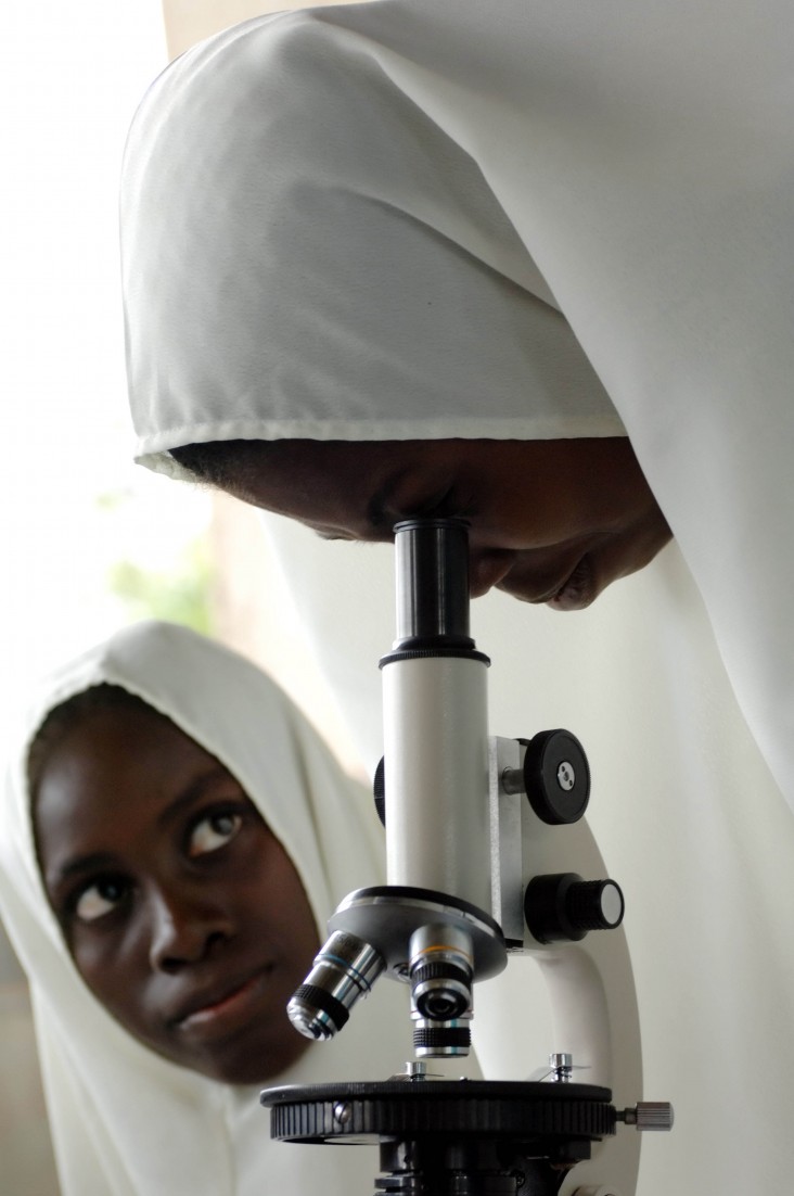 Woman looking through microsope