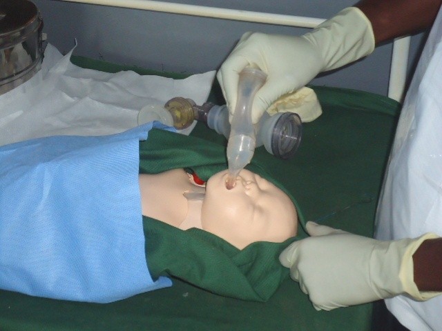 Geofrey Dzuwa demonstrates the use of an Ambu bag and a penguin sucker on a NeoNatalie, an inflatable newborn simulator.