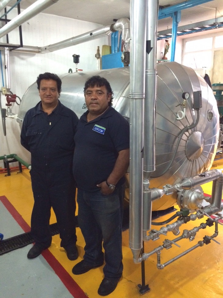 Maintenance staff Fernando Carrillo Meza, left, and Raúl Hernández stand in front of La Villa Pediatric Hospital’s water heater.