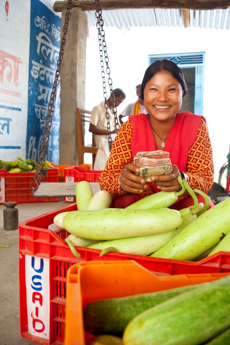 Ram Kumari Tharu displays her harvest and smiles after collecting her money from a local trader.