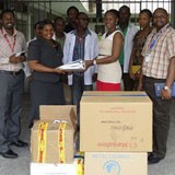 People standing behind a pile of boxes.