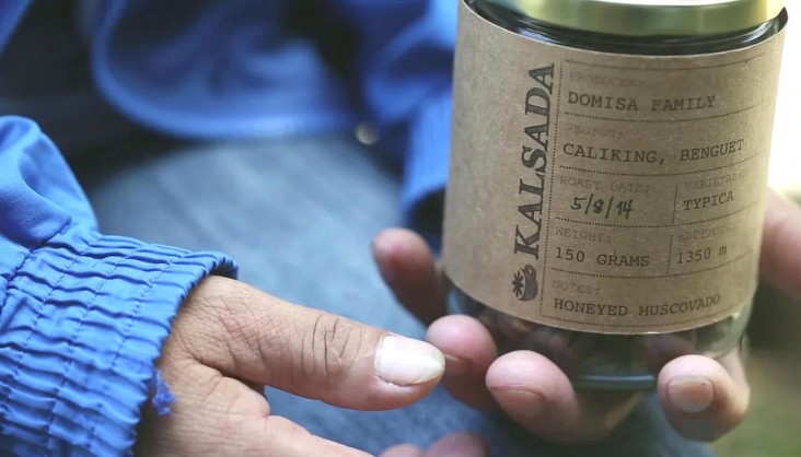 A farmer holds a jar of roasted Kalsada coffee beans that came from her farm.