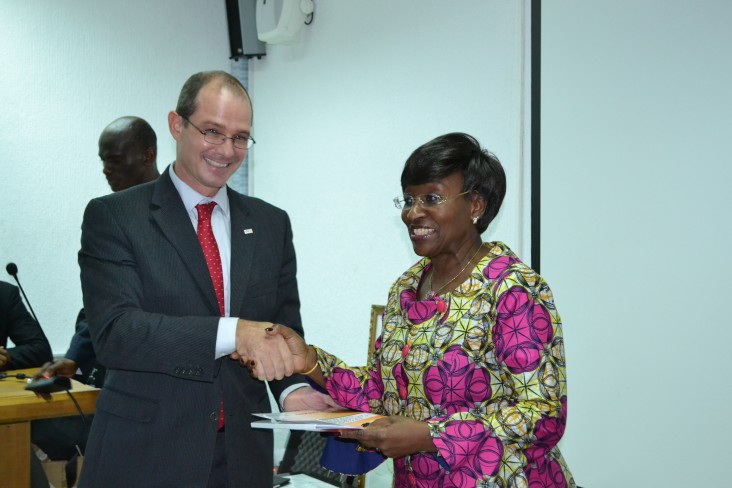 USAID Country Director shakes hand with Ivorian Minister of Health as he remits the new healthcare policy