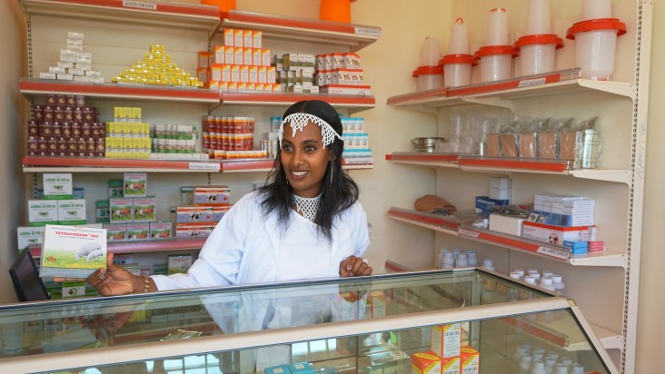 Angatu Ayansa, an employee of the Bako Farm Service Center, helps a customer in selecting merchandise.