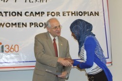 U.S. Ambassador Donald Booth presents a completion certificate to one of the 167 first-year female students.