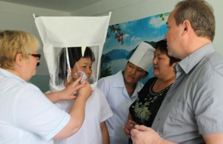 Health care workers learning to use infection control measures