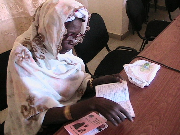 A Senegalese woman examines health insurance information.