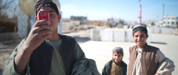  An Afghan youth uses his mobile phone to take pictures in Musa Qala, Jan. 18, 2011. 