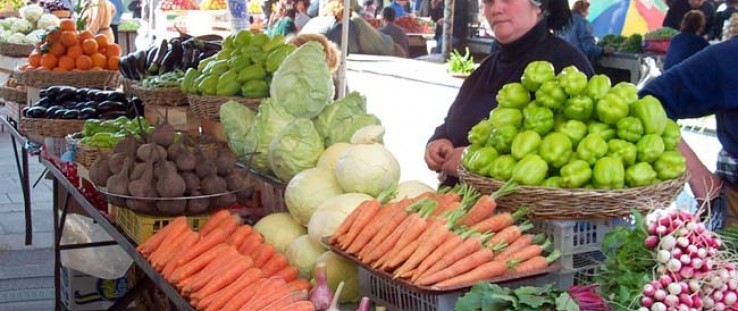 A woman sells vegetables at a local produce market in Georgia.