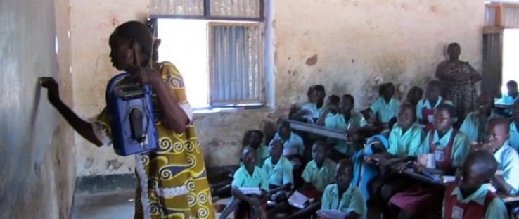 A teacher at Torit East Primary School in Torit, Eastern Equatoria state, South Sudan, holds a solar-powered, wind-up radio as s