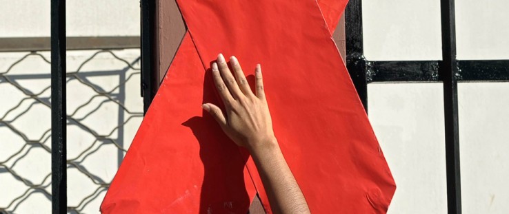 An activist sets up a red ribbon during the commemoration of the World AIDS Day in San Salvador.