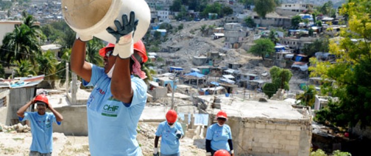 A woman catches a bucket in a line for rubble removal in the hilly Ravine Pintade neighborhood in Port-au-Prince, Haiti, Feb. 16