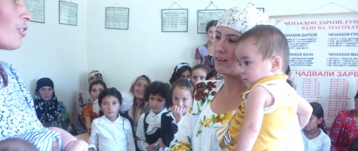 Children watch as women celebrate Breastfeeding Day in Hissor, Tajikistan.