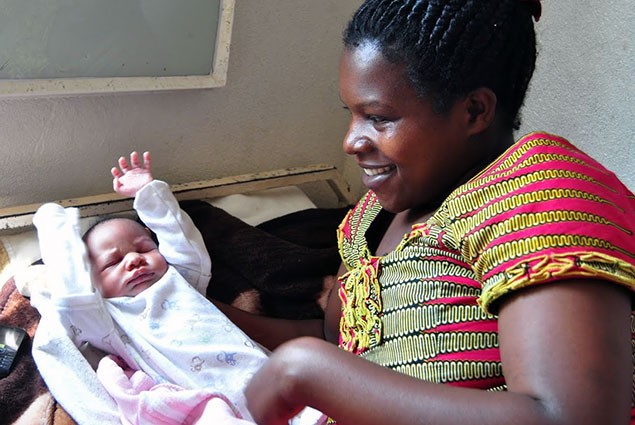 Mother smiles at her newborn child.