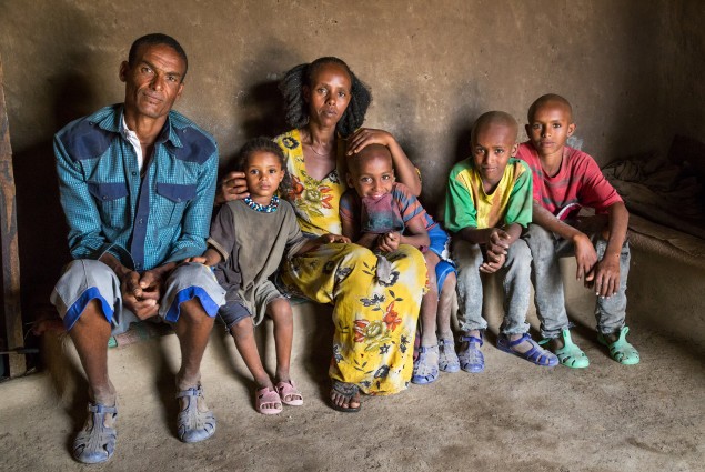 As a model farmer and VESA (village economic and social association) chairperson, Etsay Wayu (left) helps his fellow VESA members gain the knowledge, skills, and confidence they need to turn their lives around. Here Etsay is pictured at home with his family. Thanks to USAID, he and his wife, Mulu Girmay, have learned new ways to manage their farm and their income. As a result, they have more than a year's worth of food in storage.