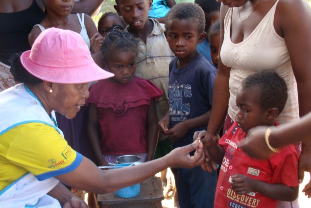 CHV administering drug to a child