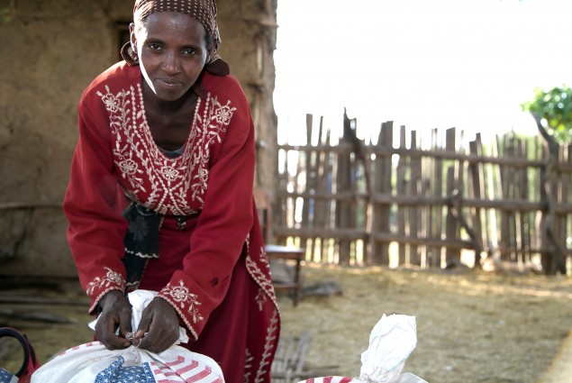 A woman prepares a food ration sack for the trip home.