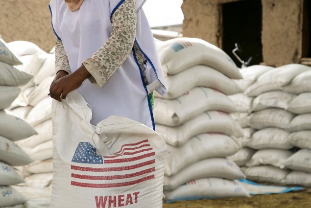 In Aje, families gather to take home rations of wheat and split yellow peas under the program, implemented by a number of national and international partners working under CRS' management.