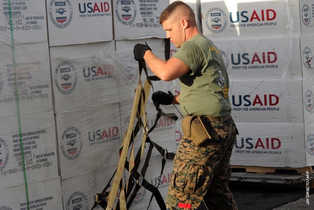 A US marine harnesses US aid goods before they are loaded on a US KC-130 plane for victims of Super Typhoon Haiyan in Tacloban, 