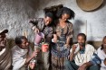 Berhe Desta and his wife Zenebu Shomoy serve customers at their tella bet (an informal bar that sells local alcohol). Berhe and his wife Zenebu work together in oxen fattening. They used some of the profit from their business to construct a new house for their family. Then they decided to generate additional income by using the front room of that house as a tella bet.