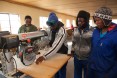 A group of men standing around a workbench