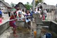 Girl pumping out water from the village's only water supply point