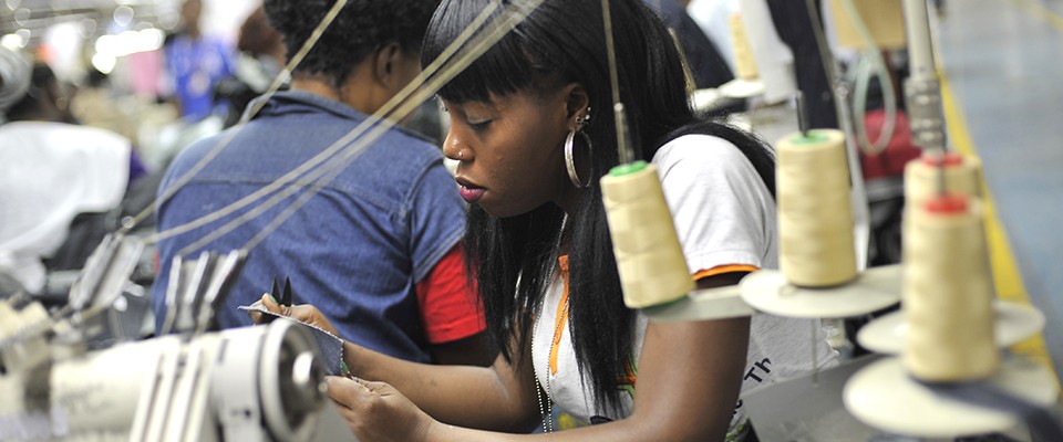 A young woman sewing clothes.