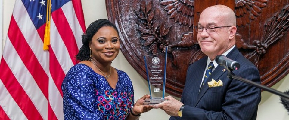 Ambassador Jackson presenting Mrs Cahrlotte Osei with the award 