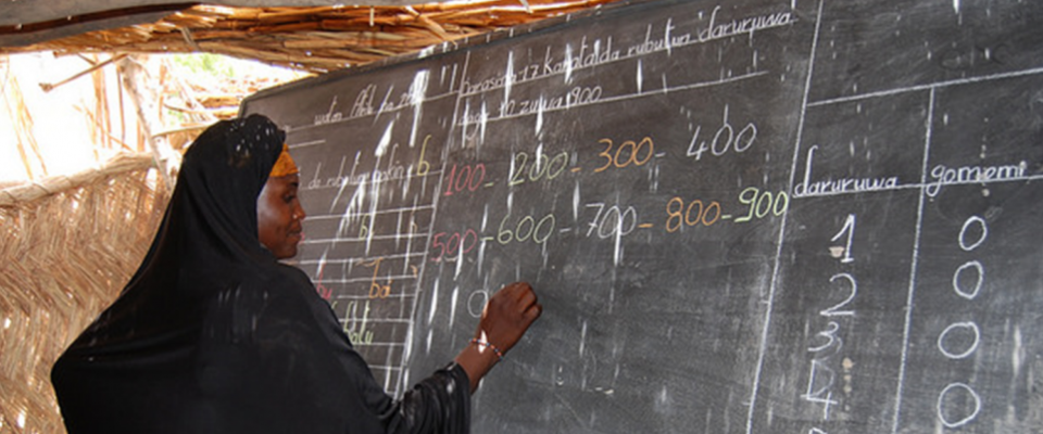 A woman writes on a chalkboard