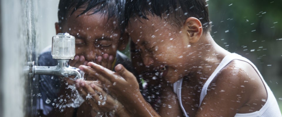 Children happily splash water to cool down. 