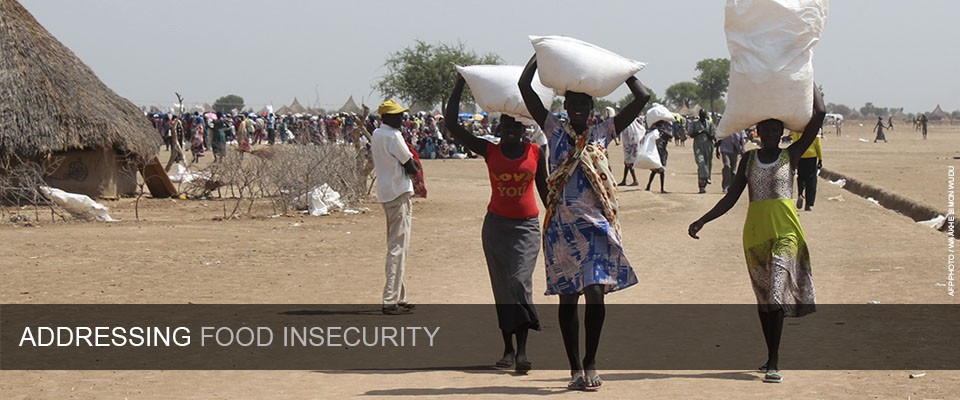 Women walk in Ganyiel village on Panyijar County of Unity State on March 20, 2015, carrying food items home distributed to them by the World Food Program (WFP) as humanitarian aid.