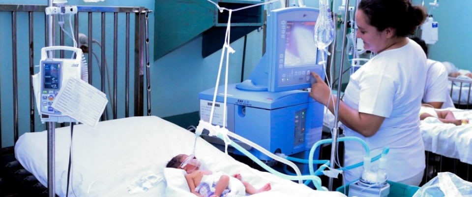 A medical worker in Guatemala attends to a newborn baby