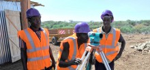 Workers survey a biomass site in Kenya.