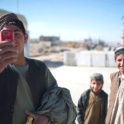  An Afghan youth uses his mobile phone to take pictures in Musa Qala, Jan. 18, 2011. 