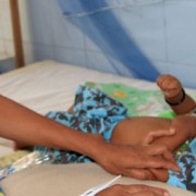 Nurse Fernanda Soares examines 5-month-old Miguel da Costa. She correctly diagnosed his pneumonia and very likely saved his life