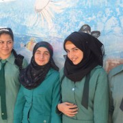 Girls in Jerash pose in front of their school’s storage tank that is painted to look like an aquarium.