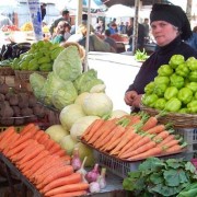 A woman sells vegetables at a local produce market in Georgia.