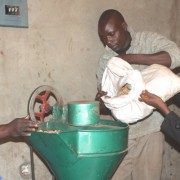 Vainess Phiri, right, and company load peanuts into the expeller.