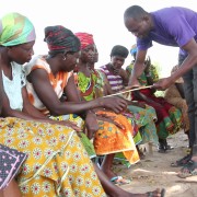 Lead farmer John Mulnye explains the row spacing planting method to smallholder women farmers.