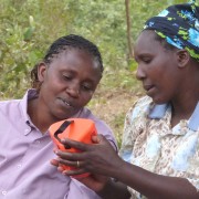 Kenyan women discuss the S300 mobile charging solar lantern.